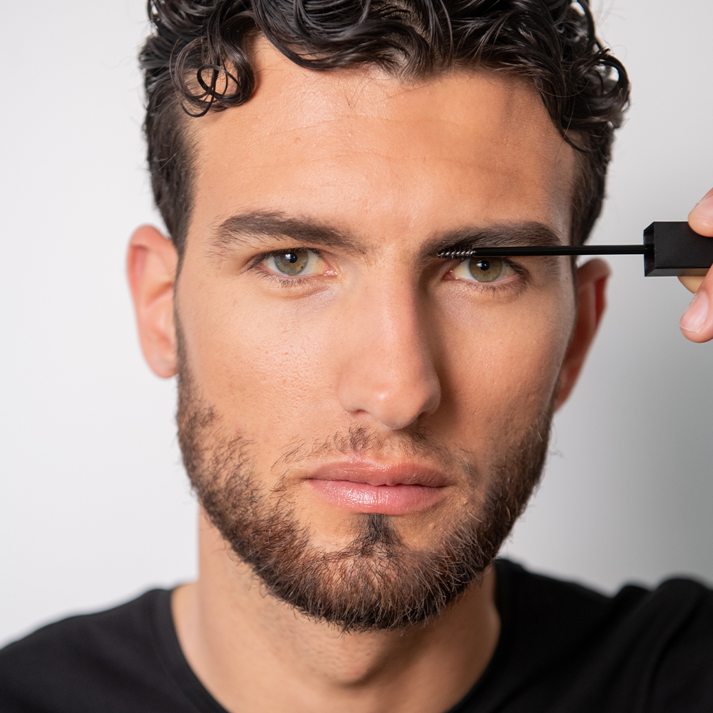 giovane-modello-intento-a-mettere-il-mascara-be-bushy-brow-mascara